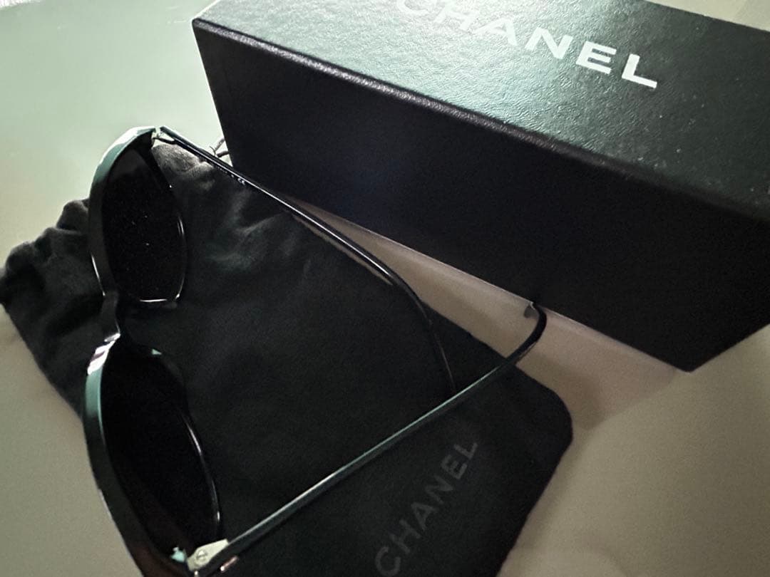 ブラックのCHANELサングラス、ケース、内袋、ロゴ付き。
