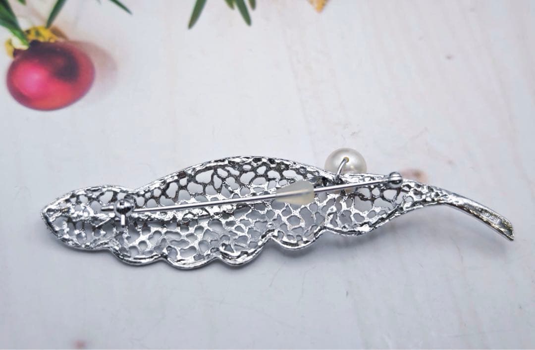 タサキのシルバーブローチはタヒチ産真珠と羽根のモチーフで装飾されています。