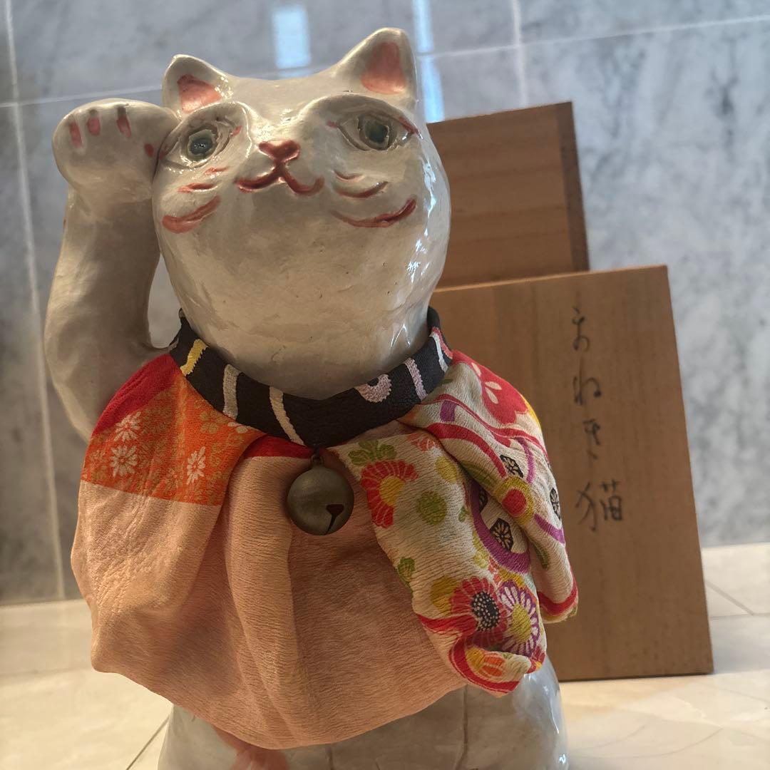 作家さんによる大きな瞳でにっこりと笑う着物の前掛けも美しい招き猫