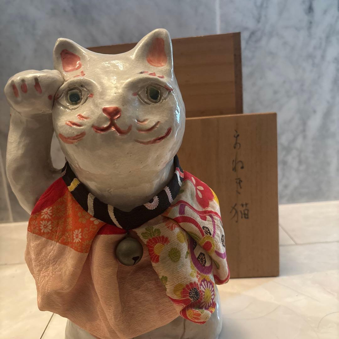 作家さんによる大きな瞳でにっこりと笑う着物の前掛けも美しい招き猫