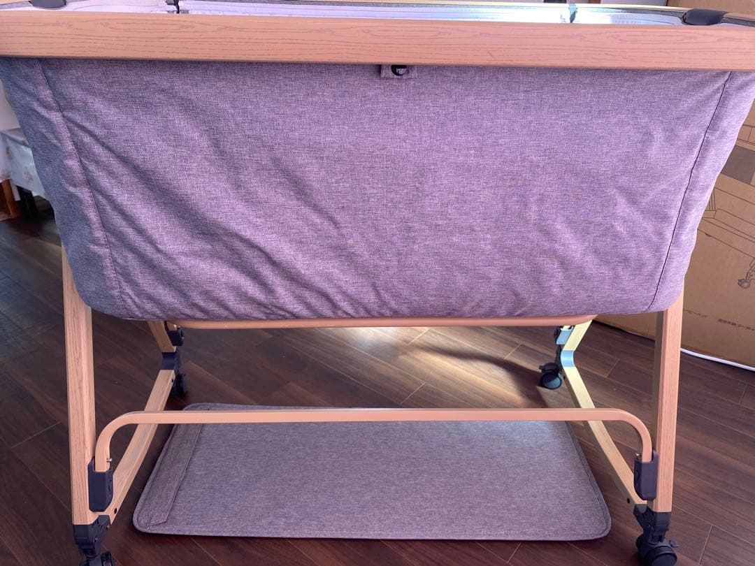 キャスター付きグレー布製ベビーベッド